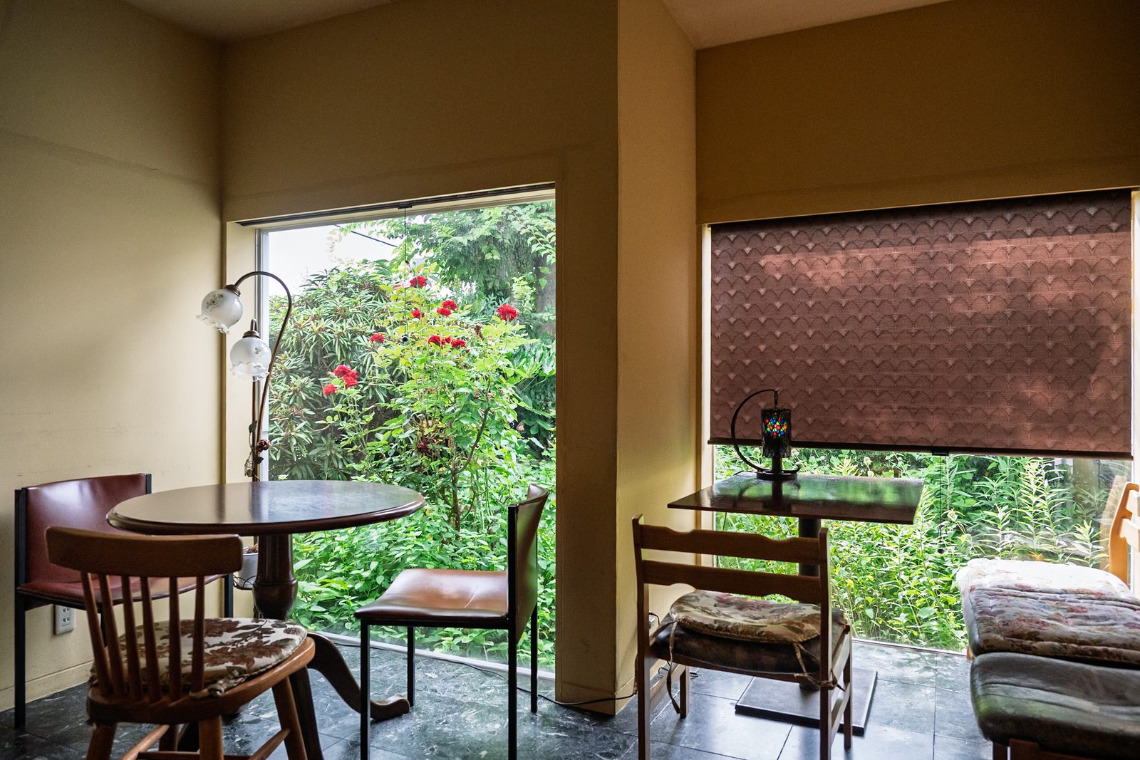บรรยากาศภายในร้านกาแฟ Otsukaya โคมไฟโบราณและเฟอร์นิเจอร์ไม้ มองเห็นสวนกุหลาบผ่านหน้าต่าง