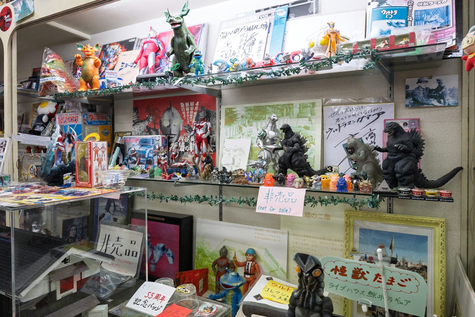ชั้นจัดแสดงฟิกเกอร์โซฟุบิ ก็อตซิลลา และแผ่นลายเซ็นติดป้าย Not for Sale ใน Shop Otsukaya